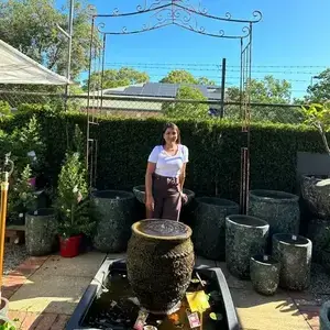 Anita Neupane standing behind a large decorative jar in Bhutan