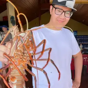 Zen Dematos holding a huge crab during a Bhutan tour